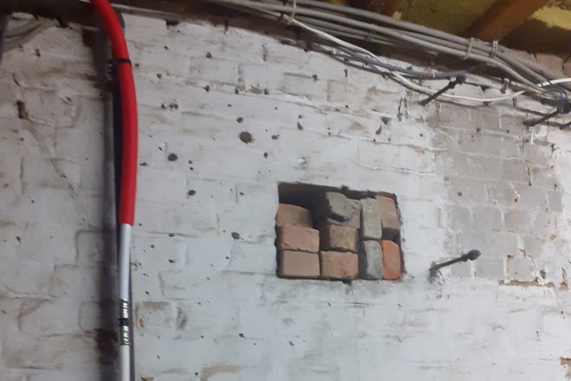 Vervanging van oude loden leidingen in een kelder door nieuwe, nette waterleiding