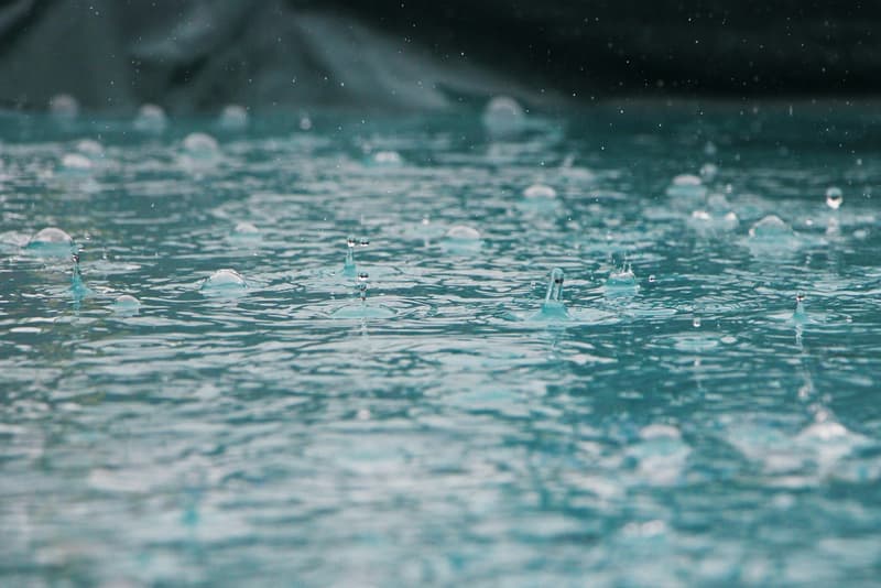 Regendruppels op een wateroppervlak — opgevangen regenwater dat wordt hergebruikt